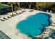 Community pool with surrounding patio and lounge chairs at 5250 Manorwood Dr # 4A, Sarasota, FL 34235