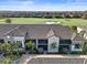 Aerial view of the condo buildings and golf course featuring meticulously maintained greenery, sand traps, and clear blue skies at 5527 Palmer Cir # 205, Bradenton, FL 34211