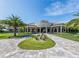 Luxury home with circular driveway, lush landscaping, and stately columns for grand curb appeal at 5527 Palmer Cir # 205, Bradenton, FL 34211