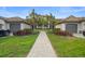 Inviting front entrance with a paver walkway, lush landscaping, and well-maintained shrubbery and attractive palm trees at 5527 Palmer Cir # 205, Bradenton, FL 34211