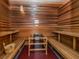 Relaxing sauna room featuring wood paneling, built-in benches, and a traditional sauna heater for a spa-like experience at 5527 Palmer Cir # 205, Bradenton, FL 34211