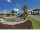 Picturesque water feature with a stone waterfall, lush landscaping, and elegant archway, creating a serene entrance at 5527 Palmer Cir # 205, Bradenton, FL 34211