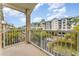 Balcony overlooking palm tree lined street and neighboring resort property with beautiful blue skies at 559 Bahia Beach Blvd, Ruskin, FL 33570