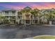 Three-story condo buildings featuring palm trees, private balconies and garage parking, set against a colorful sunset at 559 Bahia Beach Blvd, Ruskin, FL 33570