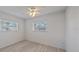 Bedroom featuring new floors, white ceiling fan, and two windows for lots of natural light at 5713 Saint Louis Ave, Sarasota, FL 34233