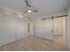 Bedroom features two closets, barn door, ceiling fan and laminate flooring at 5713 Saint Louis Ave, Sarasota, FL 34233