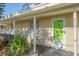 Close up of covered porch, showing green door, white trim, and house number at 5713 Saint Louis Ave, Sarasota, FL 34233