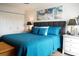 Comfortable bedroom features a plush, blue quilted bedspread and bright, colorful ocean-themed art at 5855 Midnight Pass Rd # 233, Sarasota, FL 34242