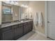 Double vanity bathroom with granite countertop and dark brown cabinets at 5892 Semolino St, Nokomis, FL 34275