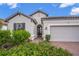 Exterior view of a house with a two-car garage and lush landscaping at 5892 Semolino St, Nokomis, FL 34275