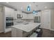 Modern kitchen with white cabinets, large island, and stainless steel appliances at 5892 Semolino St, Nokomis, FL 34275