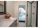 Bathroom with pool view, gray vanity, and glass shower door at 603 Saint Andrews Dr, Sarasota, FL 34243