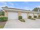 Three-car garage with white doors and landscaping at 6334 Grand Oak Cir # 201, Bradenton, FL 34203