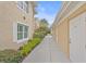 Sidewalk view of building exterior with lush landscaping at 6334 Grand Oak Cir # 201, Bradenton, FL 34203