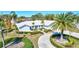 White house with circular driveway and palm trees at 6851 Country Lakes Cir, Sarasota, FL 34243