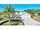 White two-story house with a three-car garage and palm trees at 6851 Country Lakes Cir, Sarasota, FL 34243