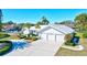 White house with three-car garage and landscaped yard at 6851 Country Lakes Cir, Sarasota, FL 34243