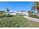 Front view of a white house with lush landscaping at 6851 Country Lakes Cir, Sarasota, FL 34243