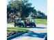 Two golf carts are parked on a paved path, surrounded by lush greenery and a charming bridge at 6851 Country Lakes Cir, Sarasota, FL 34243