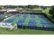 Aerial view of multiple pickleball courts at Palm Aire Country Club, surrounded by lush greenery at 6851 Country Lakes Cir, Sarasota, FL 34243