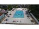 Aerial view of a community swimming pool with clear blue water, surrounded by lounge chairs and tables at 6851 Country Lakes Cir, Sarasota, FL 34243