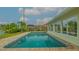 Backyard view of a refreshing swimming pool with brick pavers, complemented by lush greenery and waterfront scenery at 721 Old Compass Rd, Longboat Key, FL 34228