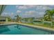 Relaxing pool with serene waterfront views of the beautiful canal and blue skies at 721 Old Compass Rd, Longboat Key, FL 34228