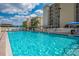 Beautiful community pool with lounge chairs, palm trees, and sunny skies at 757 Beach Rd # 300, Sarasota, FL 34242