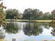 Scenic view of a tranquil pond reflecting the sky and trees, near the tenth hole of the golf course at 7619 Teal Trace, Bradenton, FL 34203