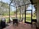 Relaxing screened porch with patio furniture, overlooking a lush backyard at 7619 Teal Trace, Bradenton, FL 34203