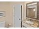 Bathroom with a granite vanity, framed mirror, and a partial view of a tiled shower at 796 Capri Isles Blvd # 242, Venice, FL 34292