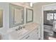 Modern bathroom with granite counters, framed mirrors, and a doorway view into a beautifully furnished bedroom at 796 Capri Isles Blvd # 242, Venice, FL 34292