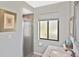 Well-lit bathroom featuring a glass-door shower and a large window, complemented by a neutral color scheme at 796 Capri Isles Blvd # 242, Venice, FL 34292