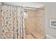 Cozy bathroom with tiled shower and tub, adorned with a decorative shower curtain and framed art at 796 Capri Isles Blvd # 242, Venice, FL 34292