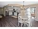 Bright dining area adjacent to the kitchen features a modern chandelier and sliding glass doors to balcony at 796 Capri Isles Blvd # 242, Venice, FL 34292