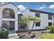 Exterior view of a well maintained condo featuring lush landscaping, a walkway, and stairs leading to the front door at 796 Capri Isles Blvd # 242, Venice, FL 34292