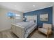 Cozy bedroom with light wood furniture and blue accent wall at 9393 Midnight Pass Rd # 302, Sarasota, FL 34242