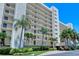 Multi-story building with palm trees and landscaping at 9393 Midnight Pass Rd # 302, Sarasota, FL 34242