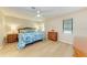 Bedroom with king-size bed, light wood floors, and wicker furniture at 96 Drifting Sands Dr, Venice, FL 34293