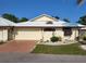 Tan one-story home with white roof, attached garage, and landscaped yard at 96 Drifting Sands Dr, Venice, FL 34293