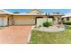 Front view of a condo with a brick driveway and well-manicured lawn at 96 Drifting Sands Dr, Venice, FL 34293