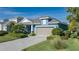 One-story home with blue siding, gray garage door, and landscaped yard at 10624 Falling Leaf Ct, Parrish, FL 34219