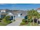 One-story home with blue siding, gray garage door, and landscaped yard at 10624 Falling Leaf Ct, Parrish, FL 34219