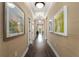 Elegant hallway with hardwood floors and framed artwork, leading to other rooms at 10624 Falling Leaf Ct, Parrish, FL 34219