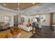 Open living room featuring hardwood floors, a cozy sofa, and a view into the kitchen at 10624 Falling Leaf Ct, Parrish, FL 34219