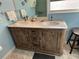 Bathroom featuring a rustic wood double vanity with marble top at 100 The Esplanade N # 6, Venice, FL 34285