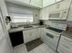 Bright kitchen with white cabinets, granite countertops, and modern appliances at 100 The Esplanade N # 6, Venice, FL 34285