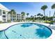 Community pool with surrounding patio and lounge chairs at 100 The Esplanade N # 6, Venice, FL 34285