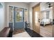 Bright entryway with blue door, bench, and view of bedroom at 1021 99Th Nw St, Bradenton, FL 34209