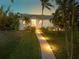 House exterior showcasing a walkway and lush landscaping at dusk at 1021 99Th Nw St, Bradenton, FL 34209